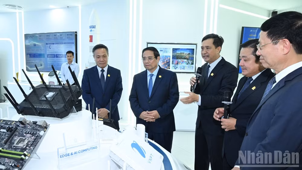 Thủ tướng Phạm Minh Chính nghe lãnh đạo Tập đoàn VNPT giới thiệu về các thiết bị công nghệ mới. (Ảnh: TRẦN HẢI).