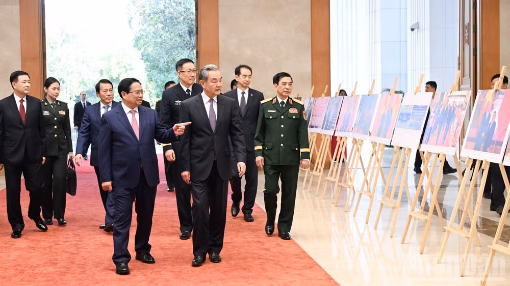 Thủ tướng Chính phủ Phạm Minh Chính giới thiệu với 3 Bộ trưởng của Trung Quốc không gian triển lãm ảnh về quan hệ hai nước. (Ảnh: TRẦN HẢI)