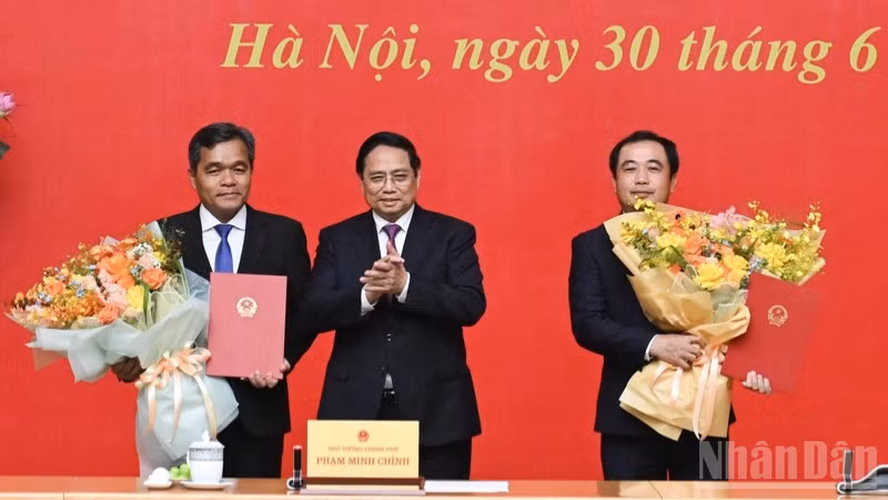 Thủ tướng Chính phủ Phạm Minh Chính trao Quyết định bổ nhiệm và tặng hoa chúc mừng hai đồng chí Trần Đức Thắng và Hồ Văn Niên. (Ảnh: TRẦN HẢI)