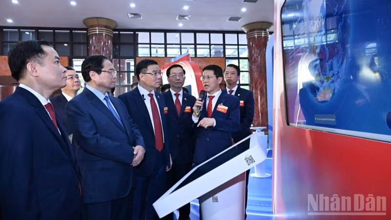 Thủ tướng Phạm Minh Chính nghe giới thiệu về những thành tựu mới trong sản xuất kinh doanh của Tập đoàn Công nghiệp-Năng lượng Quốc gia Việt Nam. (Ảnh: Trần Hải)