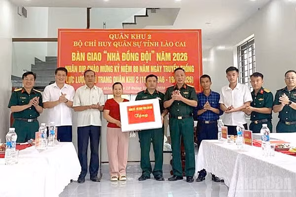 Đại tá Nhữ Đình Khoe, Chủ nhiệm Chính trị Bộ Chỉ huy Quân sự tỉnh Lào Cai trao quà tặng gia đình Đại úy Đỗ Quang Vinh. (Ảnh: THANH SƠN)