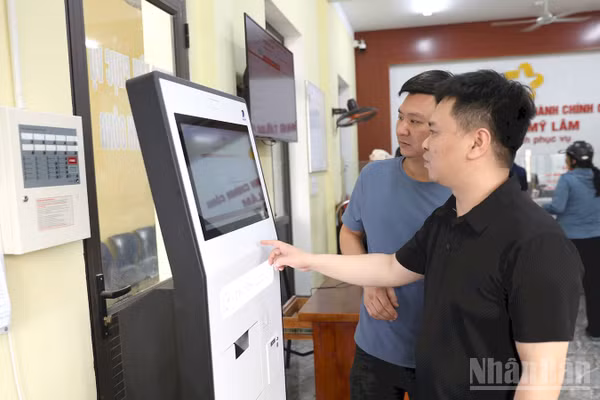 Người dân lấy số thứ tự thực hiện thủ tục hành chính tại ki-ốt tự động tại Trung tâm Hành chính công phường Mỹ Lâm. (Ảnh: Đức Thắng)
