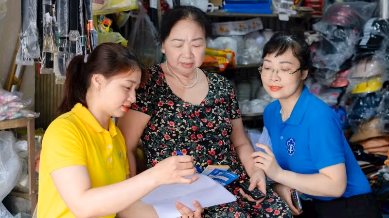 Bảo hiểm xã hội phối hợp với Bưu điện Nghệ An tuyên truyền chính sách bảo hiểm xã hội, bảo hiểm y tế đến người dân. (Ảnh: NGUYỄN ĐẠO)