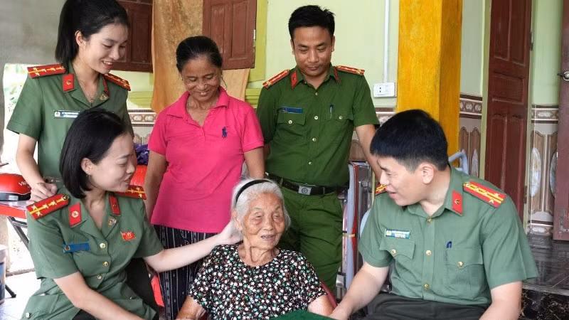 Đại tá Trần Hồng Quang, Phó Giám đốc Công an tỉnh Nghệ An ân cần thăm hỏi sức khỏe Mẹ Việt Nam Anh hùng Nguyễn Thị Năm. (Ảnh: CÔNG AN NGHỆ AN)