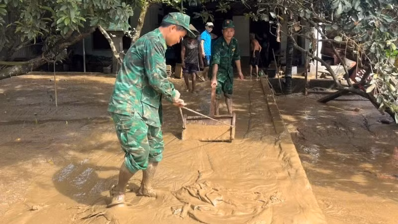 Cán bộ, chiến sĩ Bộ đội Biên phòng tỉnh Nghệ An giúp đỡ nhân dân dọn dẹp bùn đất sau lũ.