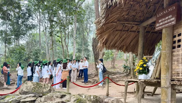Hướng dẫn viên giới thiệu cho du khách về di tích Lán Nà Nưa, Tuyên Quang. (Ảnh: HUỆ VŨ)