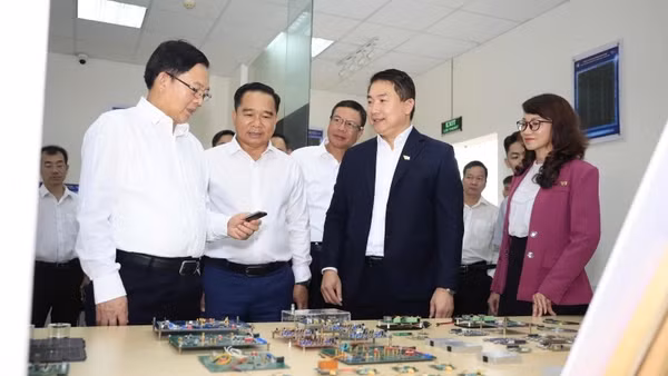Phó Thủ tướng Hồ Quốc Dũng (bên trái ảnh) tham quan phòng thí nghiệm vi mạch tại Trường đại học Bách khoa, Đại học Quốc gia Thành phố Hồ Chí Minh. (Ảnh: MỘC MIÊN)
