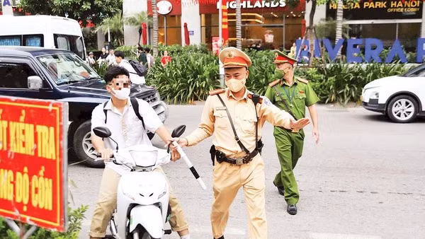 Cảnh sát giao thông xử lý trường hợp học sinh vi phạm an toàn giao thông (Ảnh PHẠM CÔNG)