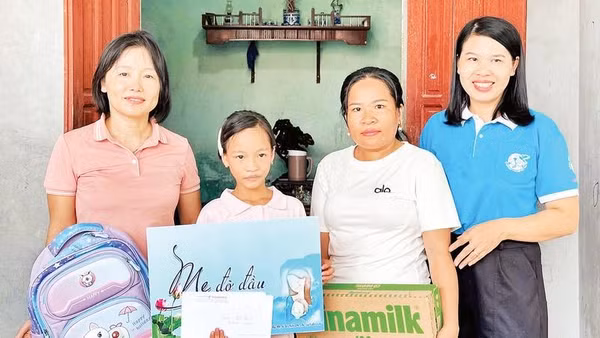 Cháu Hoàng Thị Linh Đan được chị Nguyễn Thị Ánh Tuyết (áo hồng) nhận làm con đỡ đầu từ khi vừa mất mẹ.