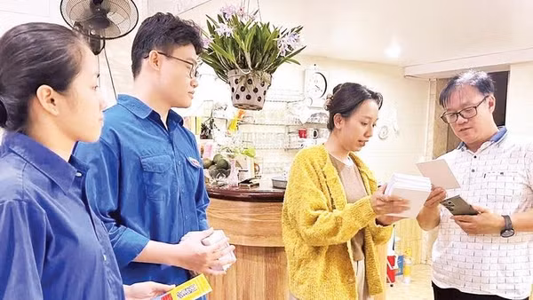 Thành viên tổ công nghệ số cộng đồng của phường Hồng Bàng hướng dẫn người dân sử dụng những tiện ích số (Ảnh HUY VŨ)