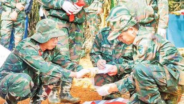 Lực lượng chức năng cẩn trọng, tỉ mỉ và giữ gìn sự tôn nghiêm trong quá trình cất bốc hài cốt liệt sĩ.