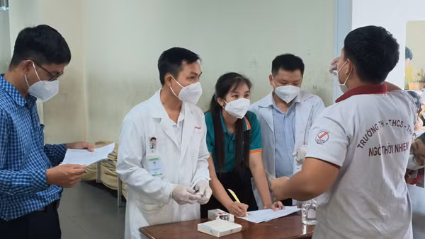 Học sinh tiếp xúc gần với ca bệnh được hướng dẫn uống kháng sinh dự phòng. (Ảnh: HCDC)