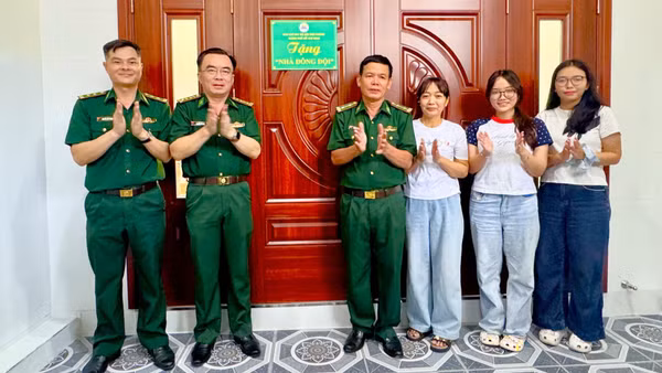 Trung tá Đồng Quang Linh (thứ tư từ phải sang) nhận bàn giao Nhà đồng đội. (Ảnh: QUANG ANH)