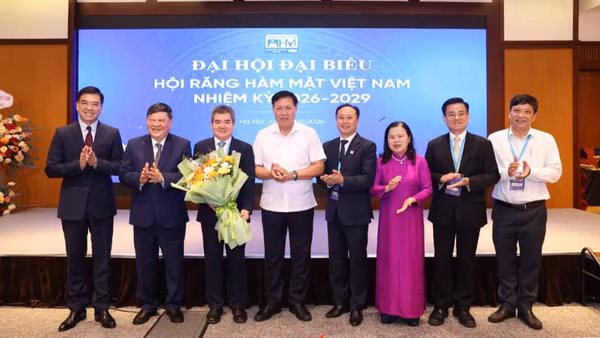 Thứ trưởng Y tế Đỗ Xuân Tuyên (áo trắng) chúc mừng tân Chủ tịch Hội Răng Hàm Mặt Việt Nam. (Ảnh: CTV)