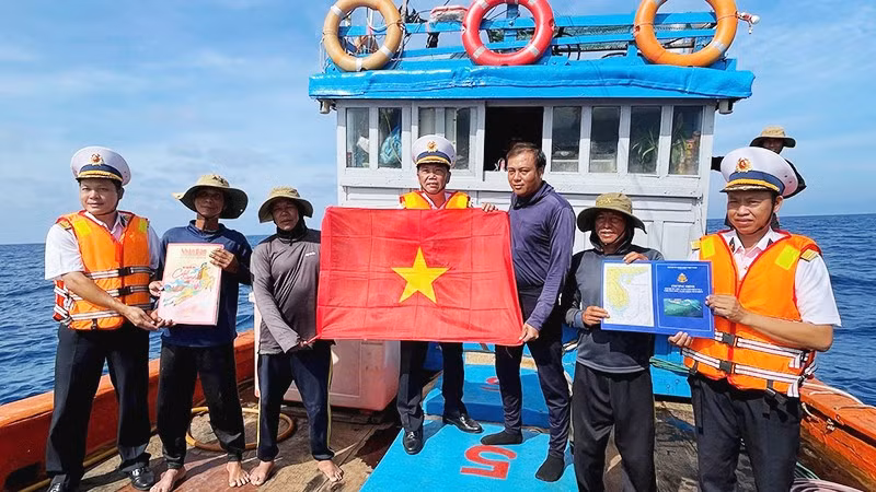 Tổ Bầu cử trao cờ Tổ quốc và quà cho các ngư dân tàu QNg 96435 TS, sau khi các ngư dân tàu hoàn thành bầu cử.
