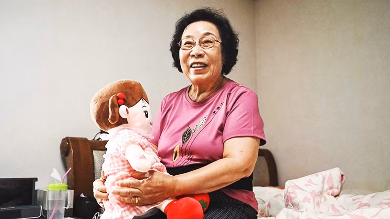 Bà Bang bên cạnh búp bê AI của mình. Ảnh: AFP