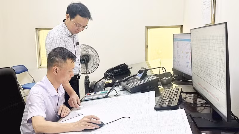 Anh Vũ Đình Thành (ngồi), nhân viên Trung tâm Điều hành vận tải đường sắt (Tập đoàn Đường sắt quốc gia Việt Nam), trong ca trực điều độ chạy tàu tuyến Vinh-Đồng Hới.