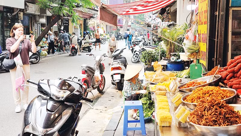 Hàng hóa bày bán trên hè ngõ Cầu Gỗ.