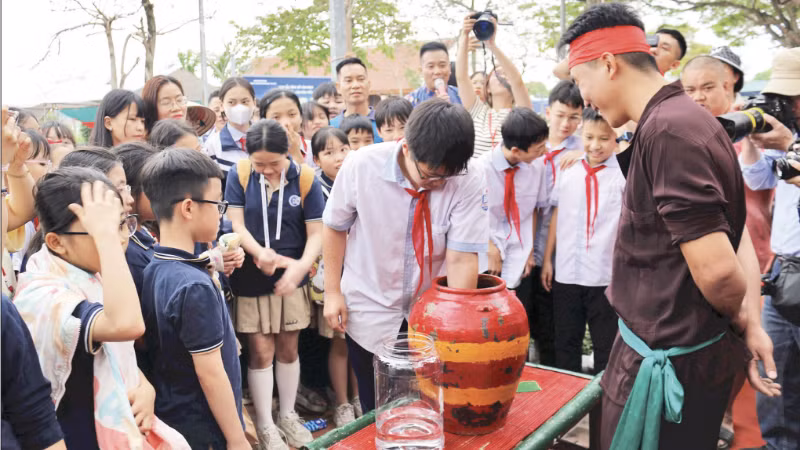Học sinh thử tài bắt chạch trong chum tại phường rối Đào Thục, xã Thư Lâm, Hà Nội.