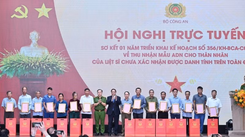 Thủ tướng Chính phủ Phạm Minh Chính trao Thông báo kết quả giám định ADN hài cốt liệt sĩ cho đại diện thân nhân các gia đình liệt sĩ. (Ảnh: TRẦN HẢI) 