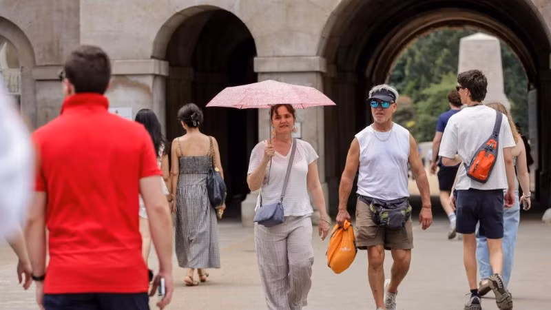 Một người phụ nữ che ô tránh nắng trong đợt nắng nóng tiếp diễn ở London, Anh, ngày 1/7/2025. (Ảnh minh họa: TÂN HOA XÃ)