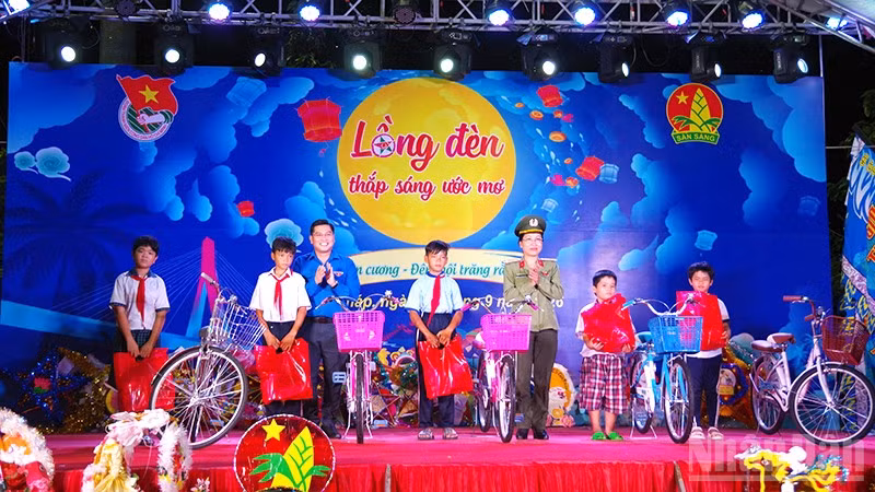Lãnh đạo Tỉnh đoàn và Công an tỉnh Đồng Tháp trao xe đạp tặng thiếu nhi có hoàn cảnh khó khăn xã Gia Thuận. (Ảnh: HỮU NGHĨA)