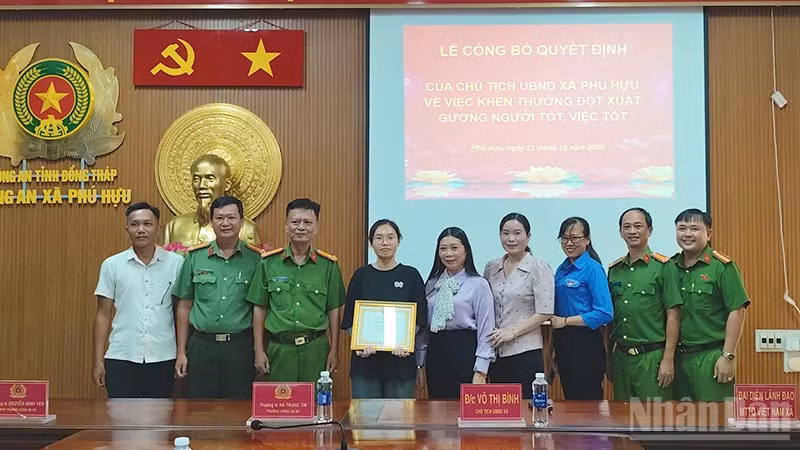 Bà Võ Thị Bình, Chủ tịch Ủy ban nhân dân xã Phú Hựu, tỉnh Đồng Tháp, (đứng thứ 5 từ phải qua trái) trao khen thưởng đột xuất cho em Phạm Nguyễn Anh Thư.