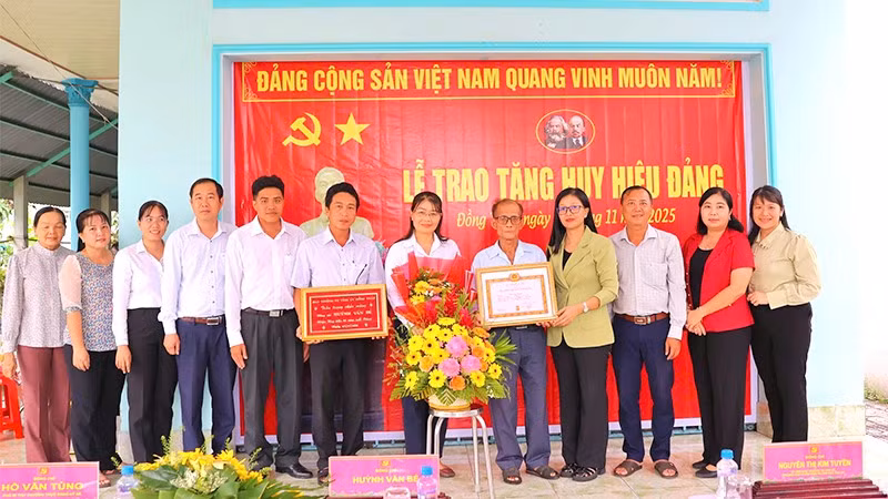 Trưởng Ban Tuyên giáo và Dân vận Tỉnh ủy Đồng Tháp Nguyễn Thị Kim Tuyến (Đứng thứ 4 từ phải sang) cùng đại diện cấp ủy xã Mỹ Thọ chụp hình lưu niệm cùng đảng viên Huỳnh Văn Bé tại lễ trao Huy hiệu Đảng.