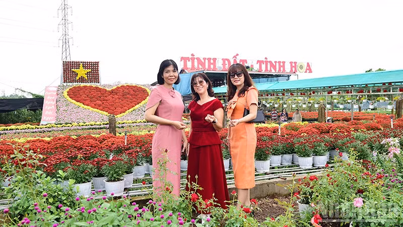 Du khách chụp hình tại tiểu cảnh “Trái tim” hoa khổng lồ có diện tích khoảng 70m2 làm từ 1.600 chậu hoa tươi như dừa cạn, cúc pico và cúc mâm xôi. Lá cờ hoa làm bằng 100 chậu hoa xác pháo màu đỏ và cúc pico màu vàng. Tiểu cảnh đặt tại Tổ hợp tác Sản xuất và cung ứng hoa, kiểng Tân An (phường Sa Đéc).
