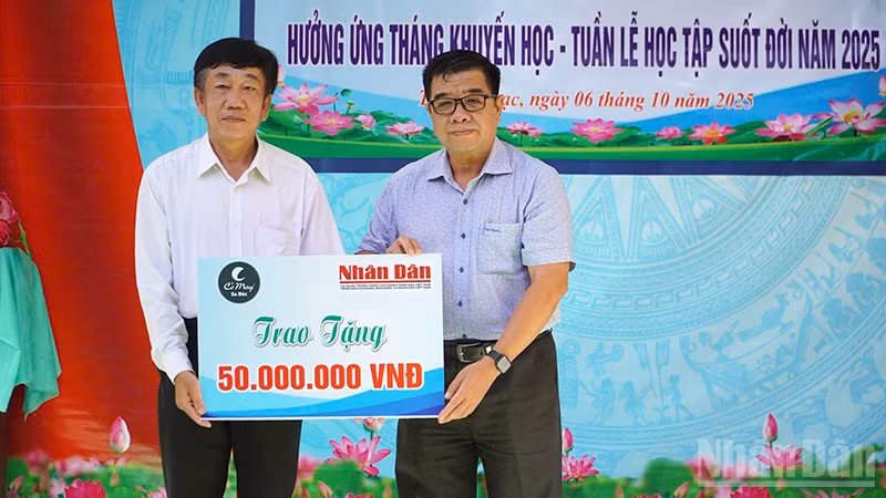 Ông Phạm Hữu Hoàn, đại diện Quỹ Xã hội Cỏ May trao 50 triệu đồng do Báo Nhân Dân vận động Quỹ để hỗ trợ học bổng tặng học sinh tại chương trình Phát học bổng hưởng ứng Tháng Khuyến học-Tuần lễ học tập suốt đời năm 2025.