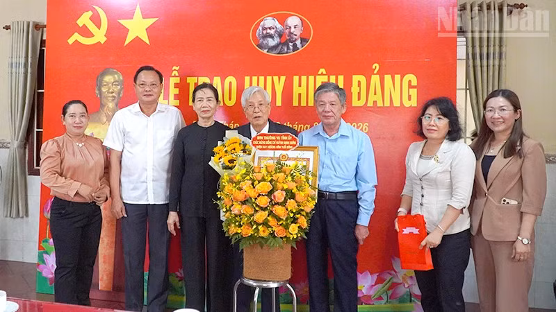 Bí thư Tỉnh ủy Đồng Tháp Ngô Chí Cường (thứ 3 từ phải qua) trao Huy hiệu Đảng và tặng hoa chúc mừng đồng chí Huỳnh Minh Đoàn. (Ảnh: Hữu Nghĩa)