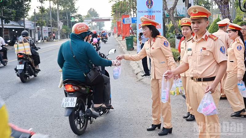 Các lực lượng phát nước suối và khăn lạnh tặng người dân về quê đón Tết.