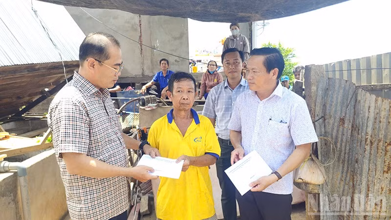 Trao tiền hỗ trợ hộ gia đình bị thiệt hại do thiên tai.