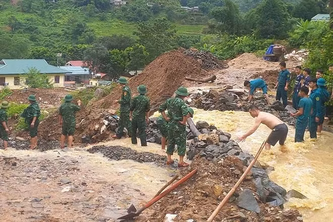 Lực lượng vũ trang ở xã Trung Lý nắn dòng chảy bảo vệ khu dân cư, cây trồng, giảm thiệt hại và khai thác công năng đường giao thông. (Ảnh: Bộ đội Biên phòng Thanh Hóa)