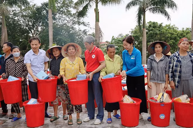 Lãnh đạo cùng các tình nguyện viên Chữ thập đỏ trao hàng thiết yếu tới nhân dân vùng thiệt hại do thiên tai ở Thanh Hóa.