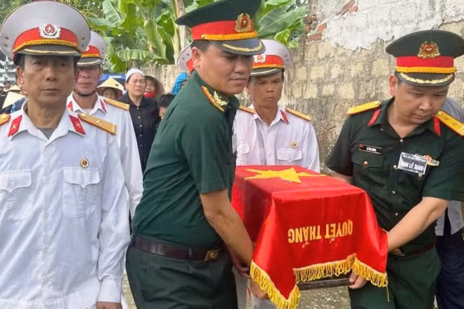 Lực lượng vũ trang cùng các cựu chiến binh di chuyển hài cốt liệt sĩ.