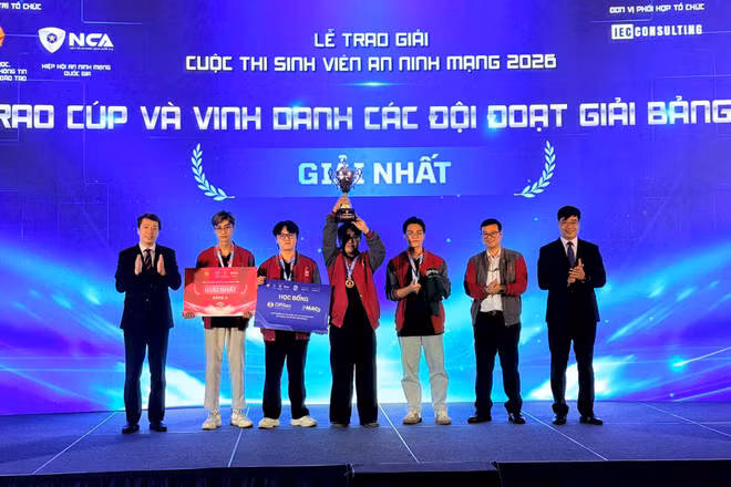 Thứ trưởng Bộ Giáo dục và Đào tạo Phạm Quang Hưng (ngoài cùng bên trái) và Phó Cục trưởng Cục An ninh mạng (A05), Bộ Công an Nguyễn Hồng Quân (ngoài cùng bên phải) trao giải Nhất cho đội thi PTIT.BW đến từ Học viện Công nghệ Bưu chính Viễn thông. (Ảnh CÔNG TÂM)