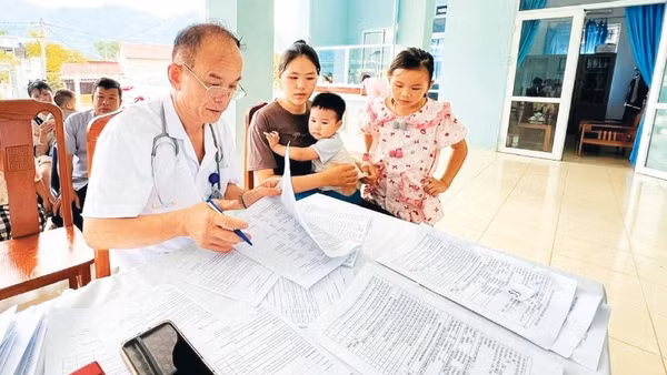 Bác sĩ Nông Văn Lực khám bệnh cho trẻ em tại Trạm y tế xã Bạch Thông.