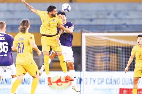 Pha tranh bóng giữa cầu thủ Hà Nội FC và Sông Lam Nghệ An (áo vàng). (Ảnh: VPF)