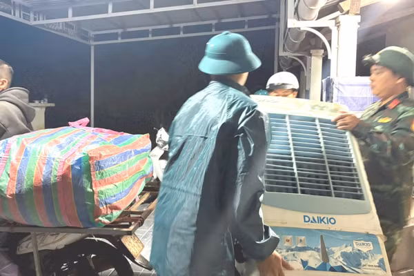 Lực lượng chức năng hỗ trợ người dân xã Lao Bảo di dời tài sản do nước lũ lên nhanh trong đêm 12/9.