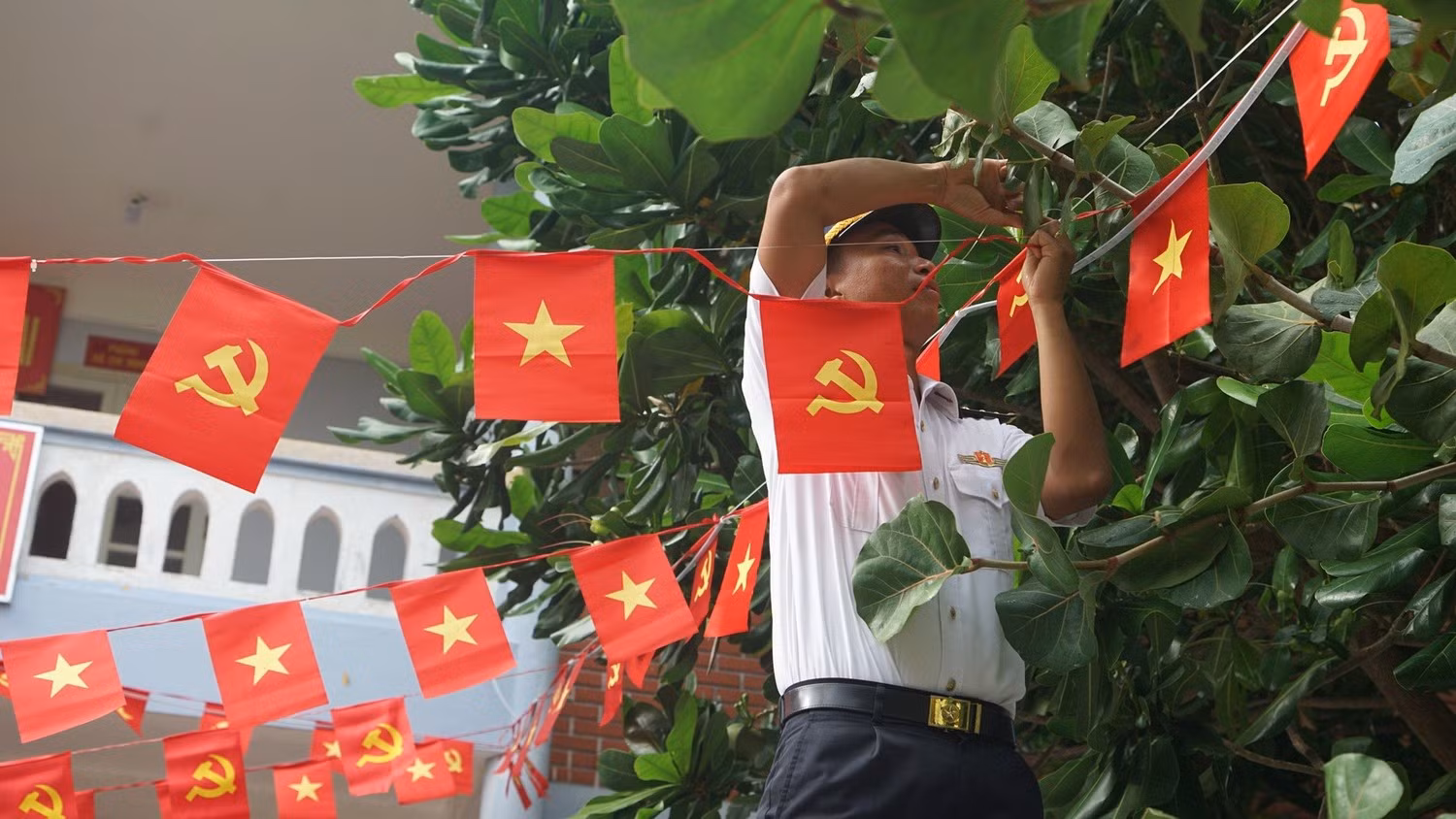 Cán bộ, chiến sĩ đảo Song Tử Tây treo cờ Đảng, cờ Tổ quốc chào mừng Đại hội XIV của Đảng. (Ảnh: TRUNG HƯNG)