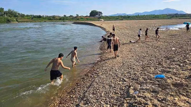 Nhiều em học sinh rủ nhau ra bãi soi dưới chân cầu Tình Húc để tắm sông mà không trang bị áo phao.