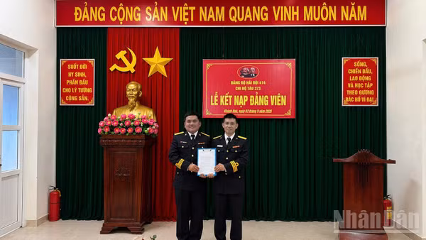 Đồng chí Thiếu tá Võ Tá Kiên, Bí thư Chi bộ Tàu 373, Hải đội 414 trao quyết định cho đồng chí Trần Văn Lượng.