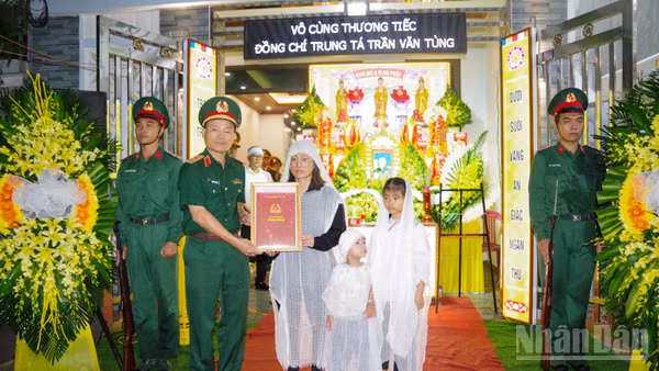 Trung tướng Lương Văn Kiểm, Phó Bí thư Đảng ủy, Tư lệnh Quân khu trao quyết định truy thăng quân hàm sĩ quan trước thời hạn của Bộ trưởng Quốc phòng cho thân nhân của Trung tá Trần Văn Tùng.