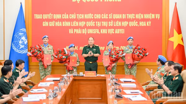Thượng tướng Lê Quang Đạo trao quyết định cho 4 sĩ quan Quân đội nhân dân Việt Nam đi thực hiện nhiệm vụ gìn giữ hòa bình Liên hợp quốc. (Ảnh: THẾ ĐẠI)