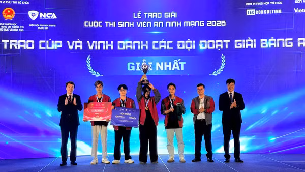 Thứ trưởng Bộ Giáo dục và Đào tạo Phạm Quang Hưng (ngoài cùng bên trái) và Phó Cục trưởng Cục An ninh mạng (A05), Bộ Công an Nguyễn Hồng Quân (ngoài cùng bên phải) trao giải Nhất cho đội thi PTIT.BW đến từ Học viện Công nghệ Bưu chính Viễn thông. (Ảnh CÔNG TÂM)