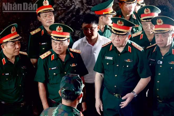 Đại tướng Nguyễn Trọng Nghĩa trao đổi với lực lượng làm nhiệm vụ tìm kiếm, quy tập hài cốt liệt sĩ tại Công viên Lê Thị Riêng. (Ảnh: Thế Anh)
