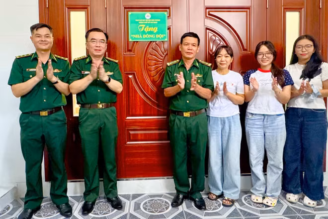 Trung tá Đồng Quang Linh (thứ tư từ phải sang) nhận bàn giao Nhà đồng đội. (Ảnh: QUANG ANH)