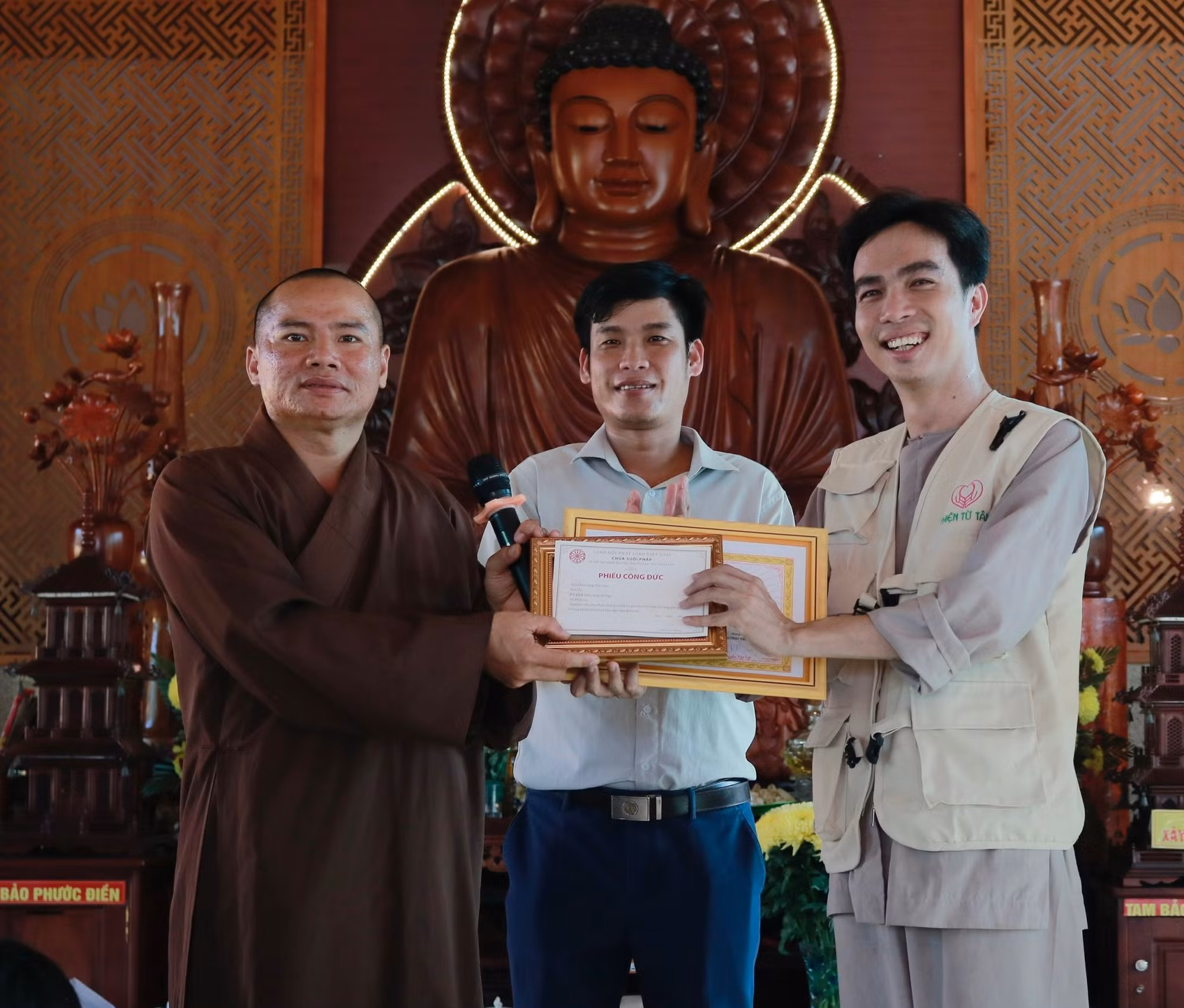 Ngô Phương Tâm (bên phải) nhận Giấy cảm ơn của UBND xã Suối Ngô và phiếu công đức của chùa Suối Pháp trong chuyến đi phát quà cho 200 hộ nghèo tại xã Suối Ngô, Tây Ninh.