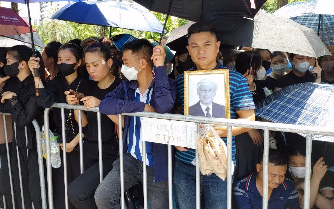 Anh Gia Minh, 40 tuổi (Chương Mỹ, Hà Nội) cầm theo di ảnh của Tổng Bí thư. Anh Gia Minh, 40 tuổi (Chương Mỹ, Hà Nội) cầm theo di ảnh của Tổng Bí thư.